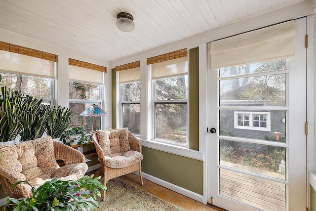 sunroom / solarium with a healthy amount of sunlight and wooden ceiling