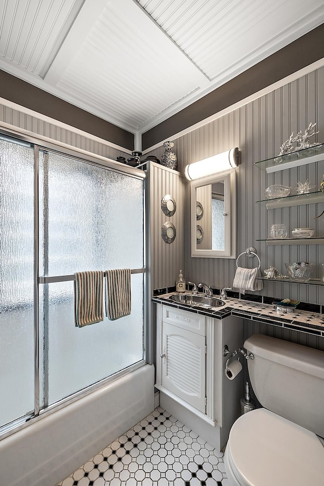 bathroom with toilet, bath / shower combo with glass door, and vanity