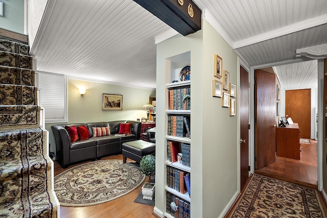 living area featuring wooden ceiling, wood finished floors, built in features, beamed ceiling, and crown molding