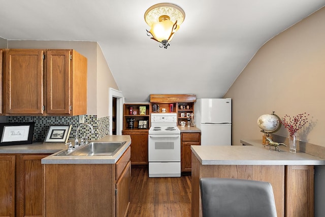 kitchen featuring a peninsula, white appliances, dark wood-type flooring, a sink, and brown cabinets