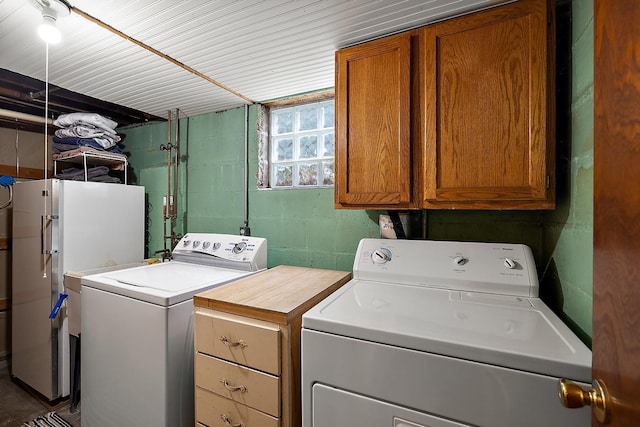 laundry room featuring separate washer and dryer and cabinet space