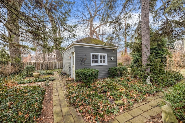 view of home's exterior featuring fence and an outdoor structure