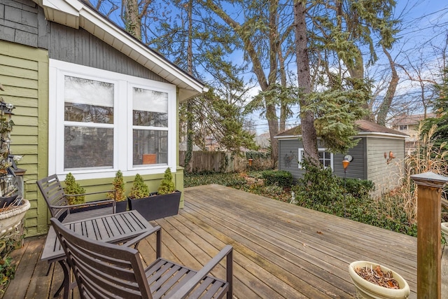 wooden terrace with an outdoor structure and fence