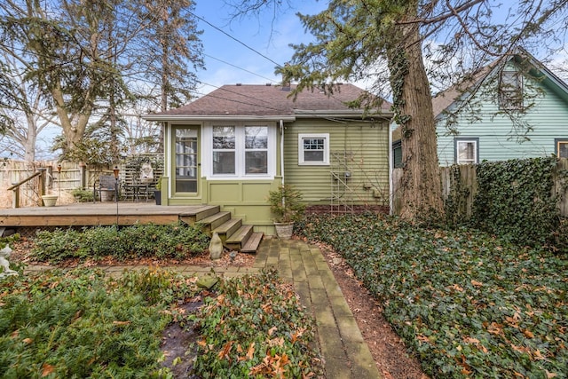 back of property featuring a fenced backyard, a shingled roof, and a wooden deck