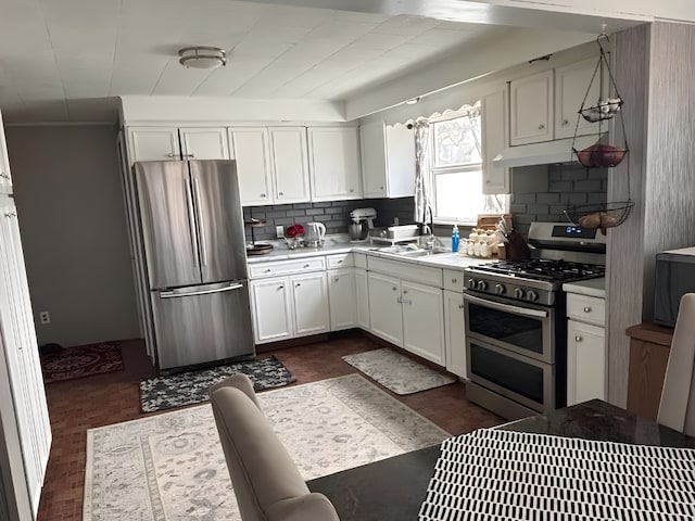 kitchen featuring appliances with stainless steel finishes, white cabinets, and a sink