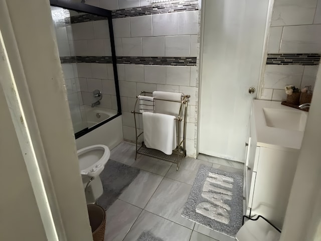 full bathroom with a sink, toilet, tile walls, and shower / bathing tub combination