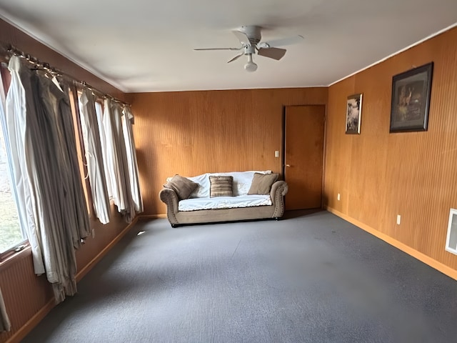 unfurnished room with ceiling fan, radiator heating unit, wood walls, and baseboards