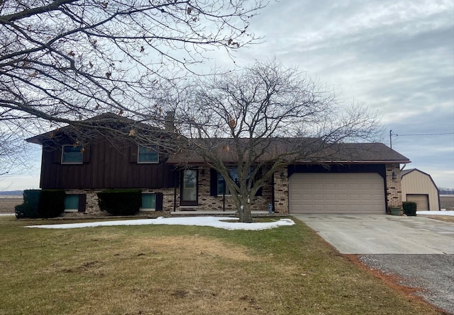 split level home with driveway, a garage, a front lawn, and brick siding