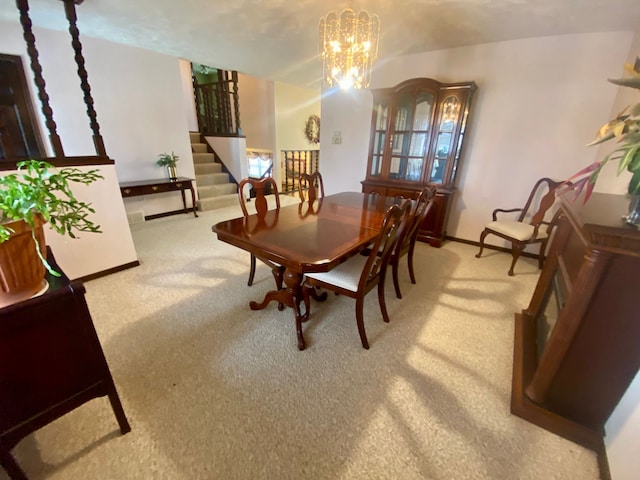 carpeted dining space with baseboards, stairway, and an inviting chandelier