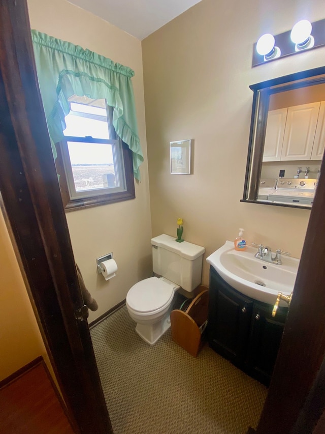 bathroom with toilet, baseboards, and vanity