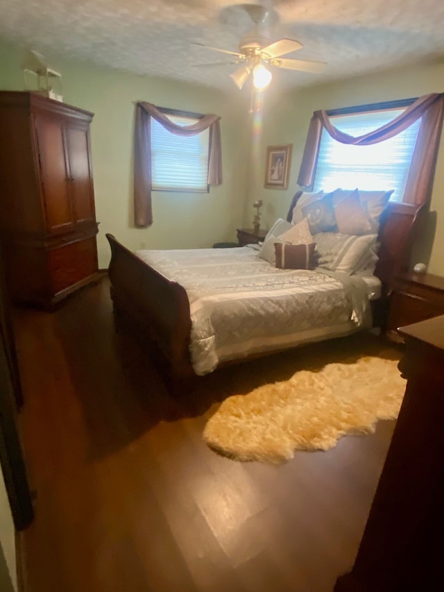 bedroom featuring a ceiling fan and dark wood finished floors