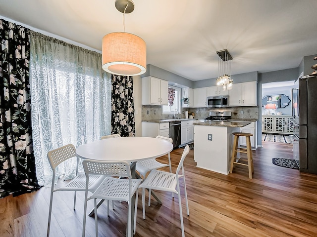 dining space with wood finished floors