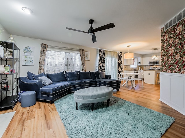 living area with light wood finished floors and ceiling fan