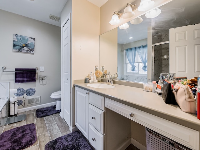 bathroom with visible vents, toilet, a stall shower, and vanity