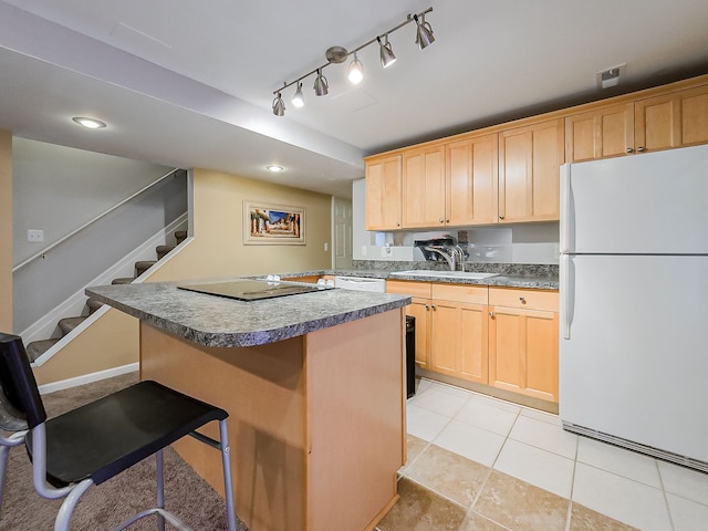 kitchen with a kitchen island, light brown cabinetry, a kitchen bar, white appliances, and a sink