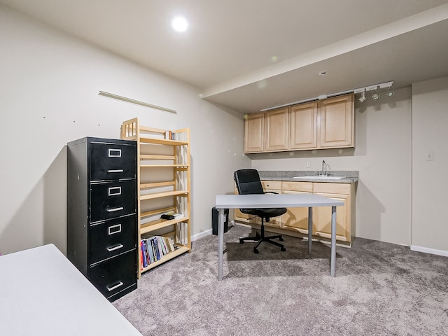 carpeted office with a sink and baseboards