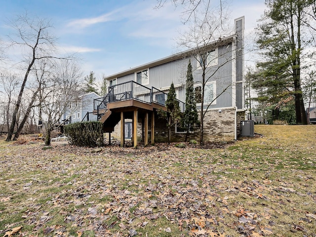 rear view of house featuring stairway, brick siding, and a wooden deck