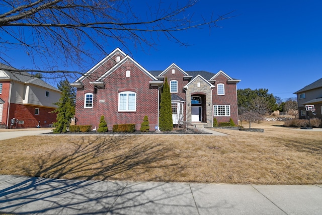 view of front of house featuring stone siding, brick siding, and a front yard