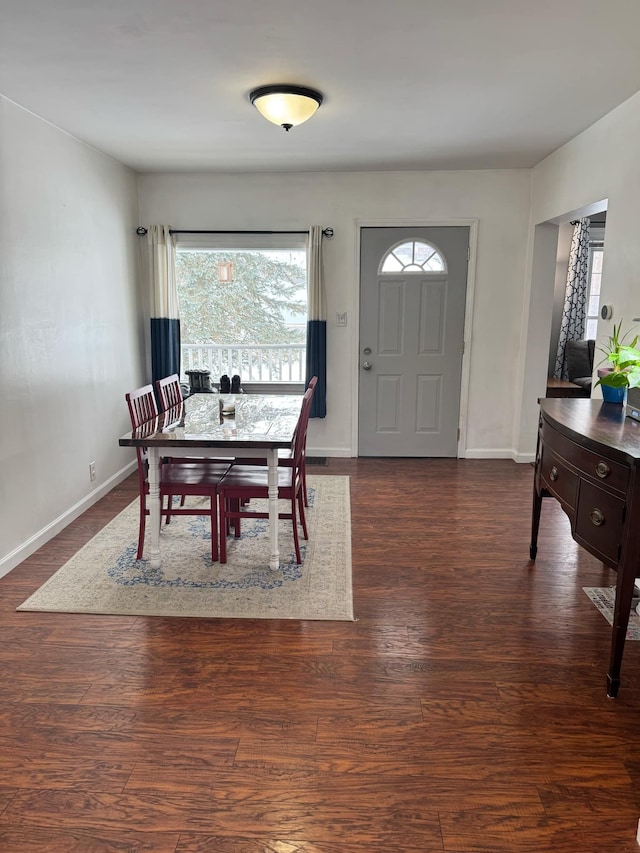 dining space featuring dark wood-style floors and baseboards