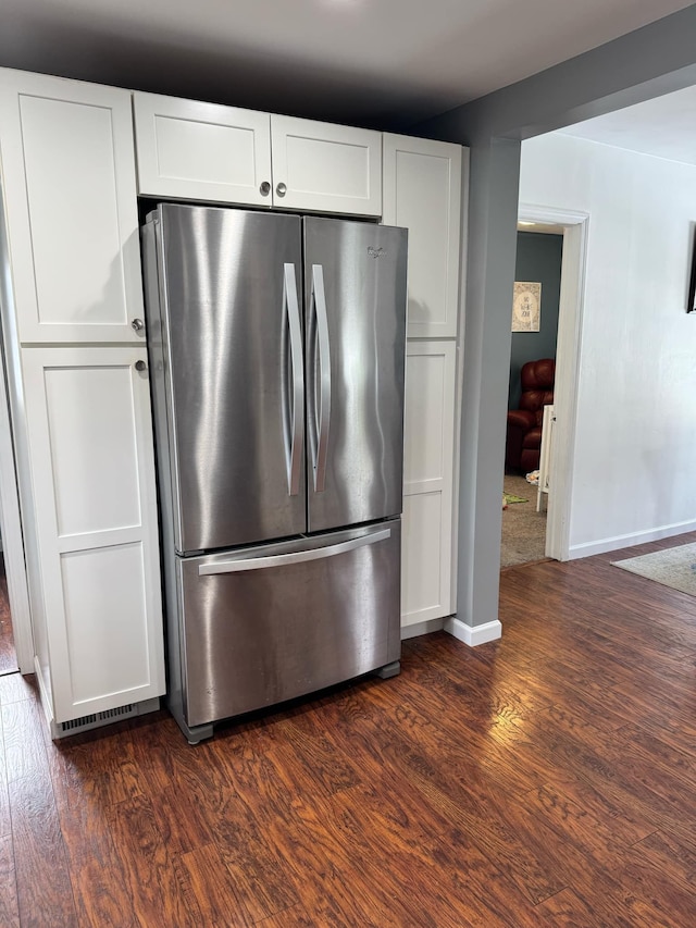 kitchen with freestanding refrigerator, dark wood-style flooring, white cabinetry, and baseboards