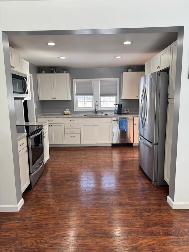 kitchen featuring dark wood finished floors, stainless steel appliances, and a sink