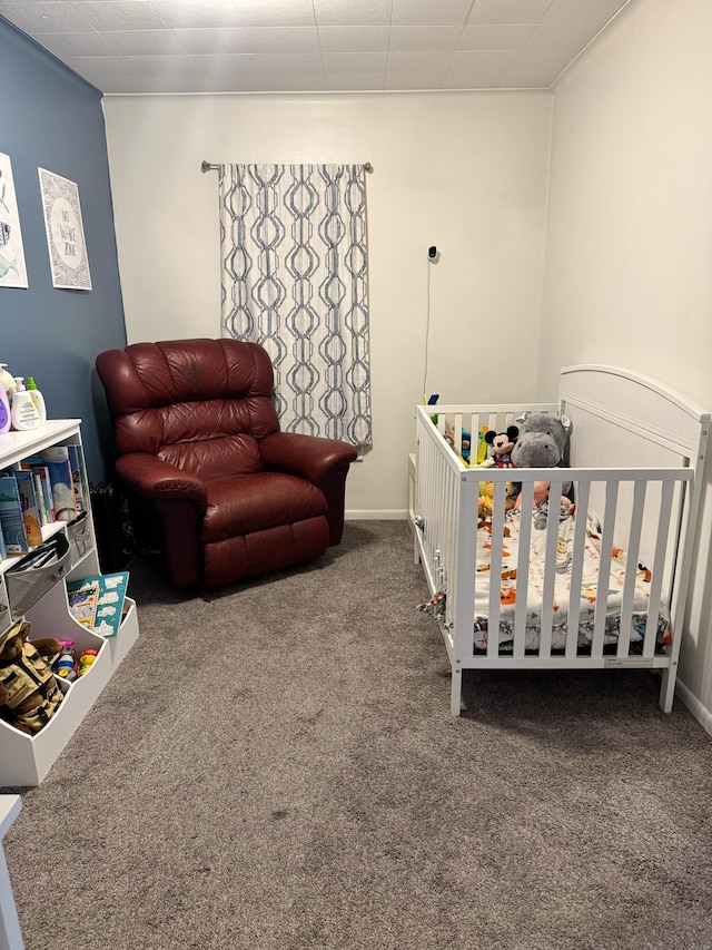 bedroom with carpet flooring, a crib, and baseboards