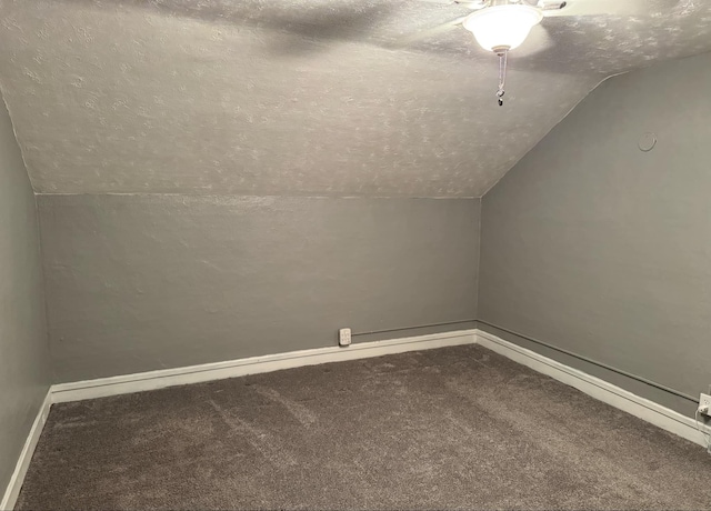 bonus room with lofted ceiling, carpet flooring, a textured ceiling, and baseboards