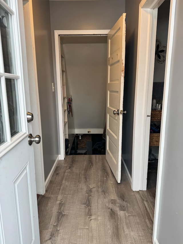 hall featuring baseboards and wood finished floors