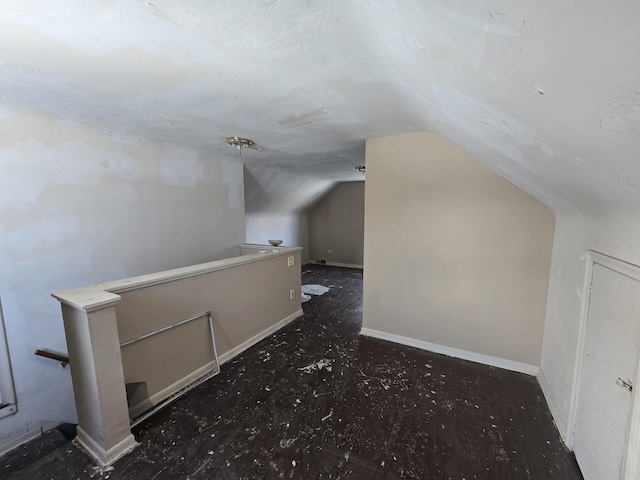 bonus room with vaulted ceiling, carpet floors, and baseboards