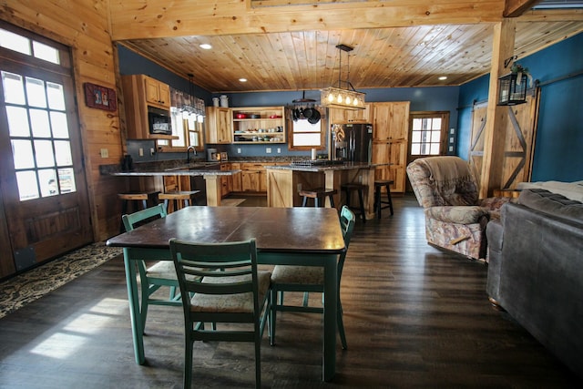 dining area featuring dark wood-style floors, recessed lighting, a barn door, wood walls, and wooden ceiling