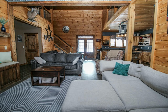 living area with stairs, wood finished floors, and wooden walls