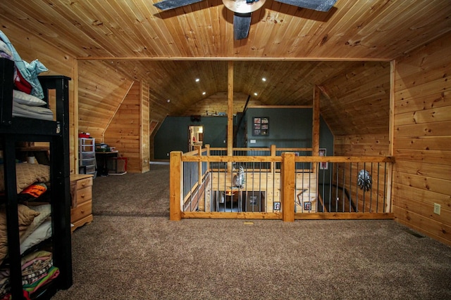 bonus room featuring wooden ceiling, carpet, a ceiling fan, and wood walls