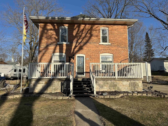 view of front of home featuring a wooden deck and brick siding