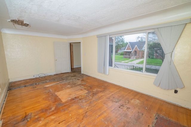 empty room featuring a textured ceiling and hardwood / wood-style floors