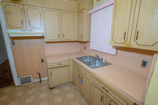 kitchen featuring light tile patterned floors, under cabinet range hood, a sink, visible vents, and light countertops