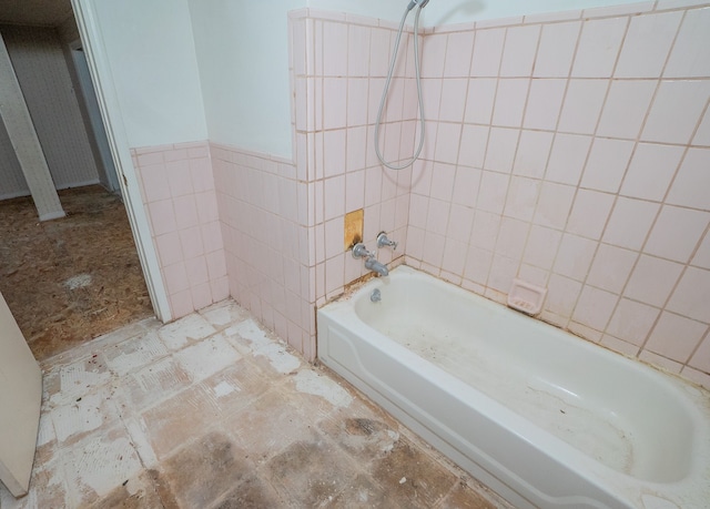 bathroom featuring a wainscoted wall, tile walls, and shower / bathtub combination