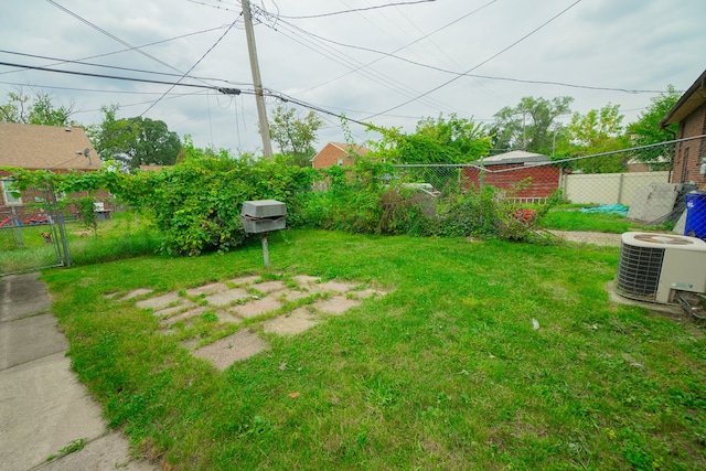 view of yard featuring fence and central AC unit