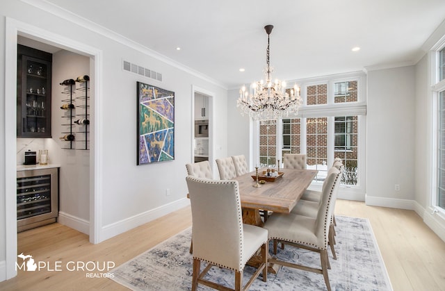 dining area with light wood finished floors, wine cooler, visible vents, and crown molding