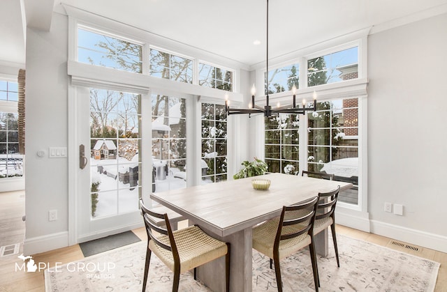 sunroom / solarium with visible vents and a notable chandelier