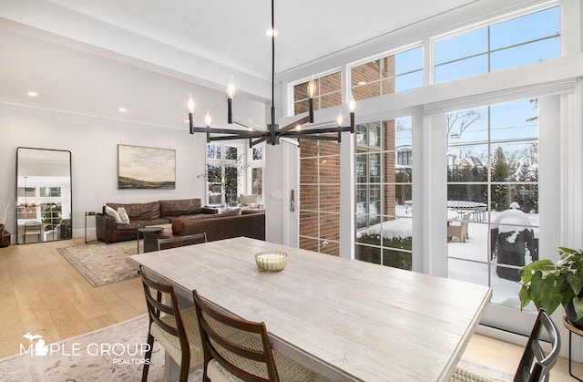 dining room with light wood-style floors, a chandelier, crown molding, and recessed lighting