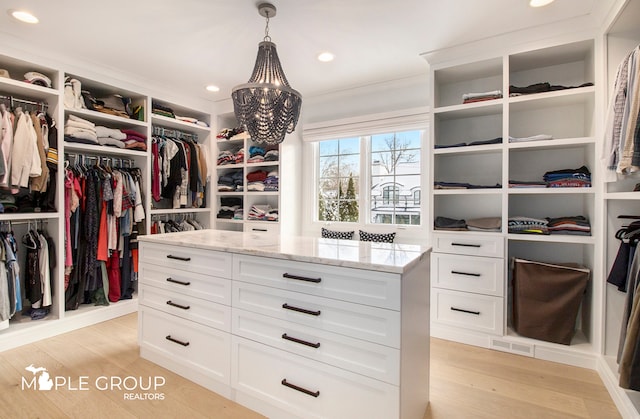 walk in closet with light wood finished floors and visible vents