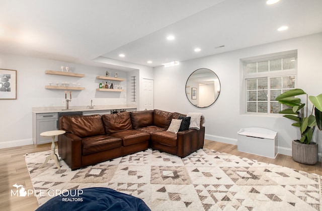 living area featuring light wood-type flooring, wet bar, and recessed lighting