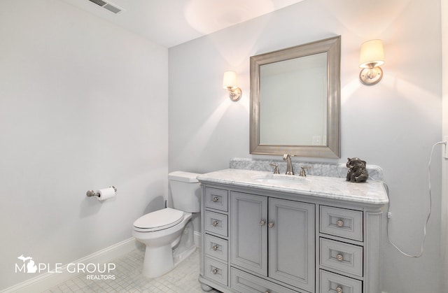 bathroom with visible vents, toilet, vanity, baseboards, and tile patterned floors