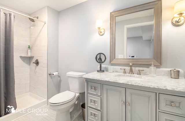 full bath featuring toilet, a tile shower, and vanity