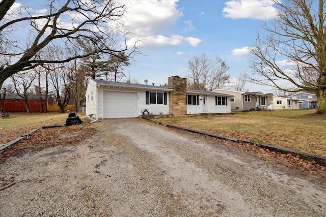 single story home featuring dirt driveway, a chimney, a front yard, and a garage