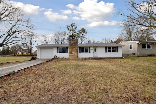 ranch-style house featuring an attached garage, driveway, a chimney, and a front yard