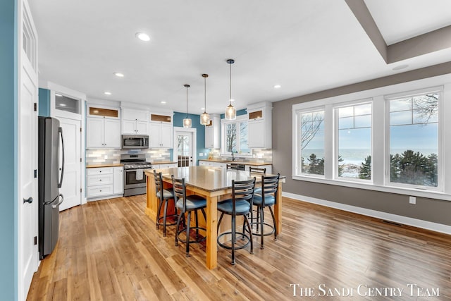 dining room featuring recessed lighting, baseboards, and light wood finished floors