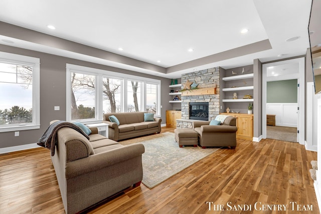 living room with plenty of natural light, a fireplace, and light wood-style flooring