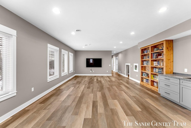 unfurnished living room featuring light wood-style floors, recessed lighting, visible vents, and baseboards