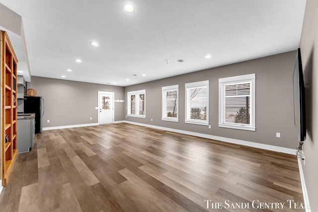 unfurnished living room featuring baseboards, wood finished floors, and recessed lighting